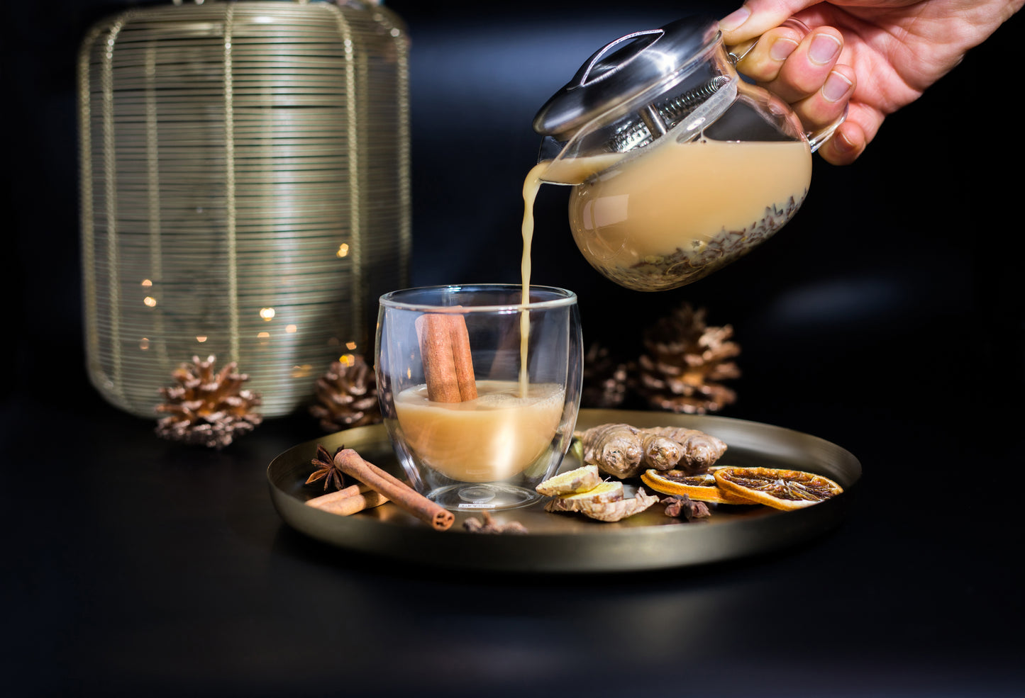Alanda's Tea BOMBAY Chai Latte wird in Doppelwandglas eingeschenkt – Zimt, Ingwer, Orange und Kardamom