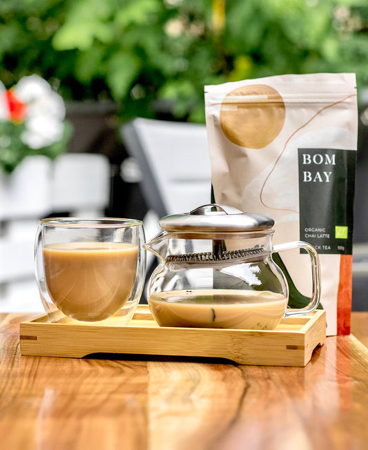 Alanda's Tea Bambus Serviertablett mit Glaskanne, Doppelwandglas und BOMBAY Chai Latte im Garten