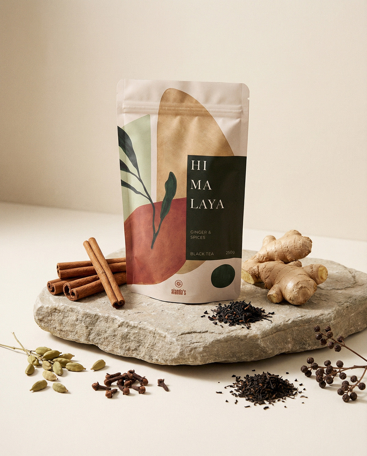 Alanda's Tea HIMALAYA Doypack mit Ingwerwurzel, Zimtstangen, Kardamom und Nelken auf Steinpodest