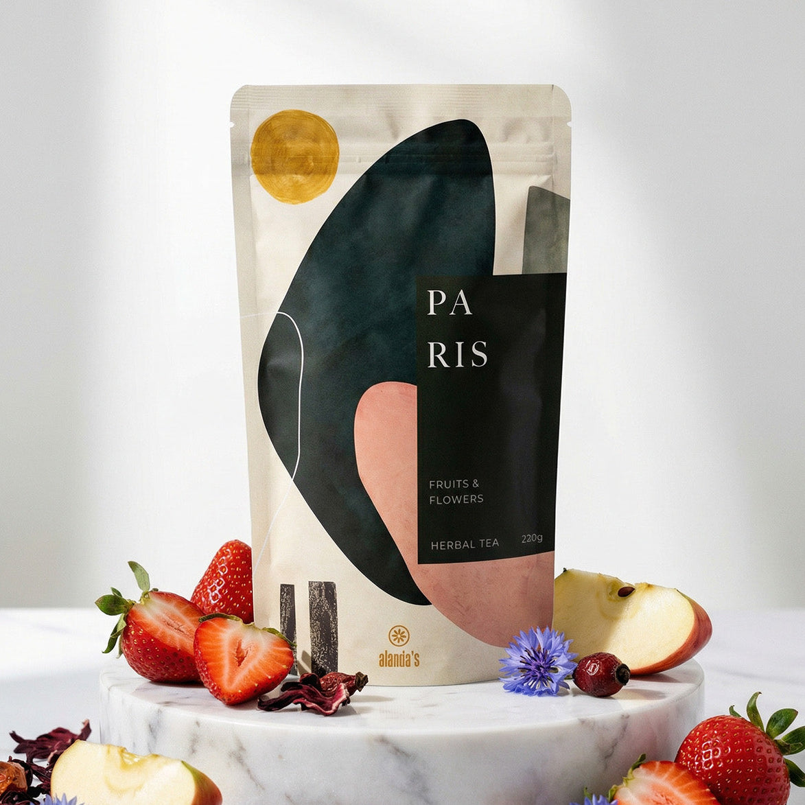 PARIS Früchte & Blüten Tee von Alanda's Tea auf Marmor mit frischen Erdbeeren, Hibiskus und Kornblumen